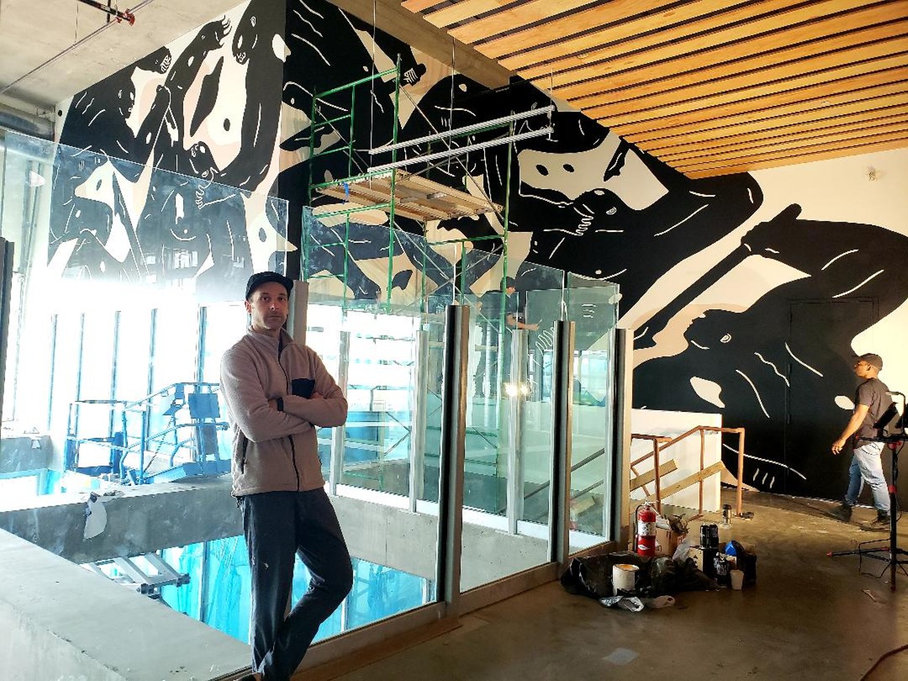 Cleon Peterson in front of his completed mural in the Source Hotel and Market Hall.