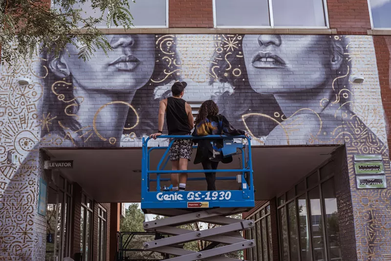 Image: Two muralist admire their work from a crane