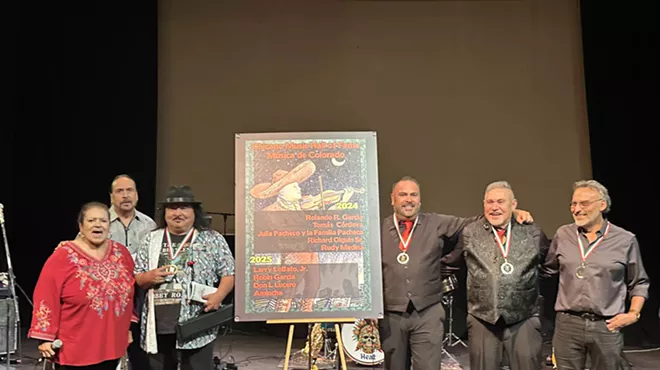 The four inductees of the Chicano Music Hall of Fame stand before a crowd on stage at Su Teatro Cultural & Performing Arts Center.