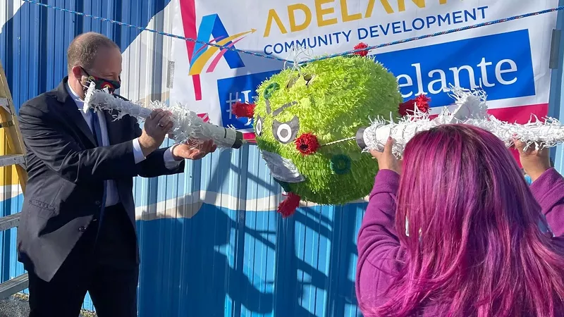 Image: At a February 26 vaccination event, Governor Jared Polis jammed a faux-hypodermic into an angry-looking COVID-19 piñata.