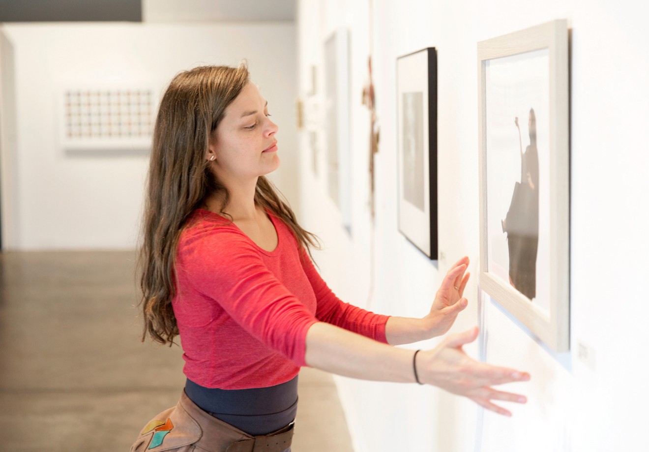 Jessica Kooiman Parker adjusts an artwork in the gallery.
