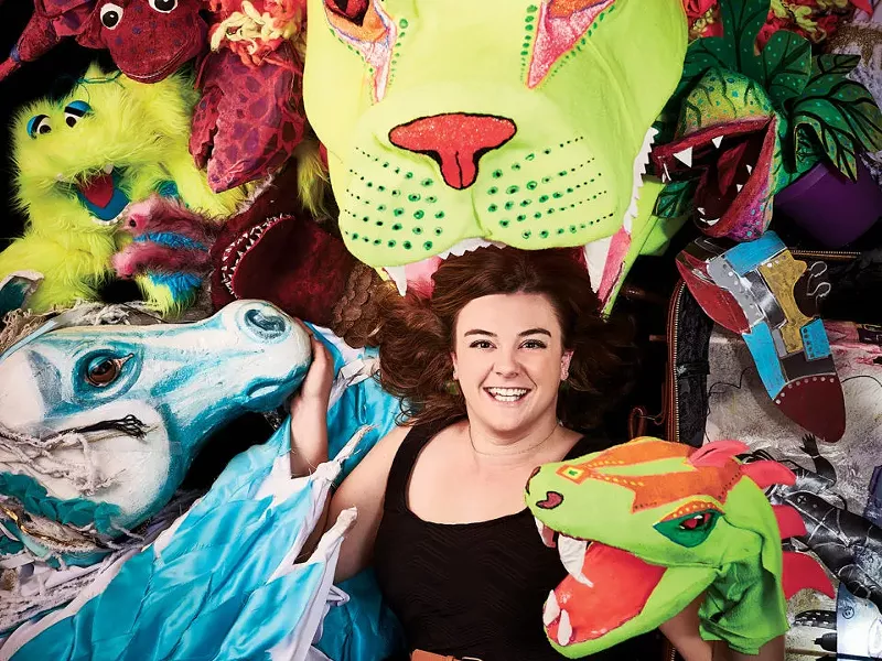 Image: Katy Williams poses with all her colorful puppet creations.