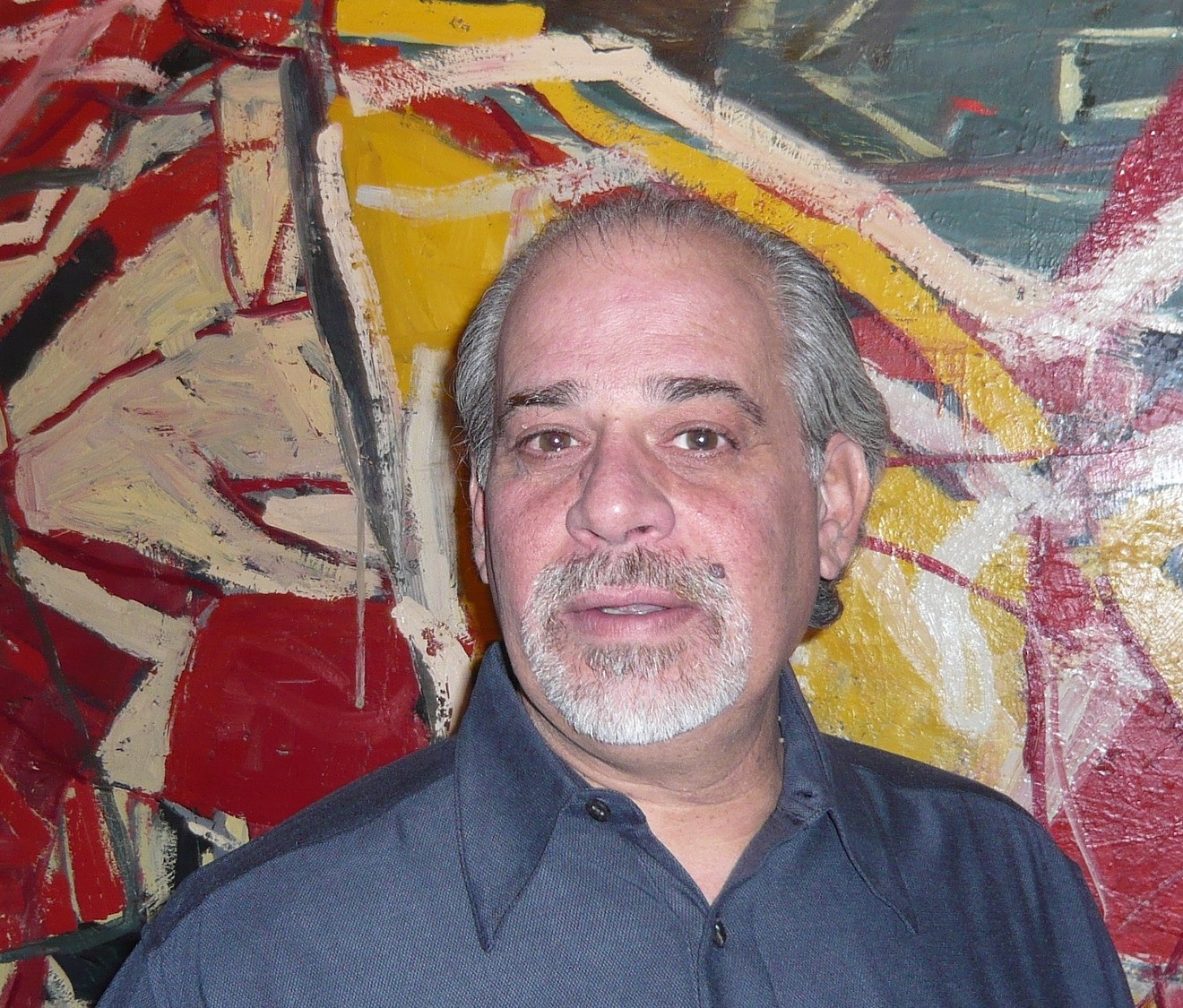Michael Paglia with a Mark Villarreal painting in the background, 2015.