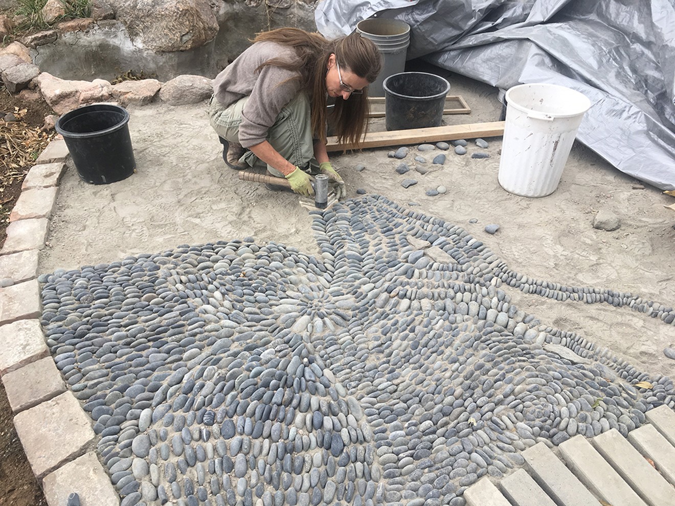 Sabin Aell builds a pebble-mosaic patio at Neu Hinterland in Morrison.