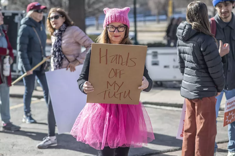 Image: woman in pink tutu and hat with sign supporting abortion