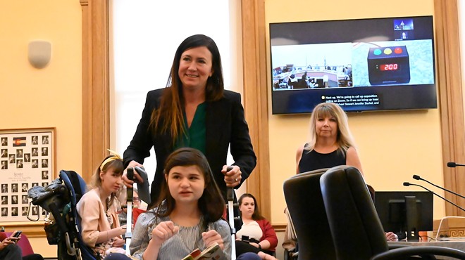 Liz Cochran walks away from the panel after testify before the Senate Finance Committee about the importance of CBD products for her disabled daughter, who is in the wheelchair in front of her.