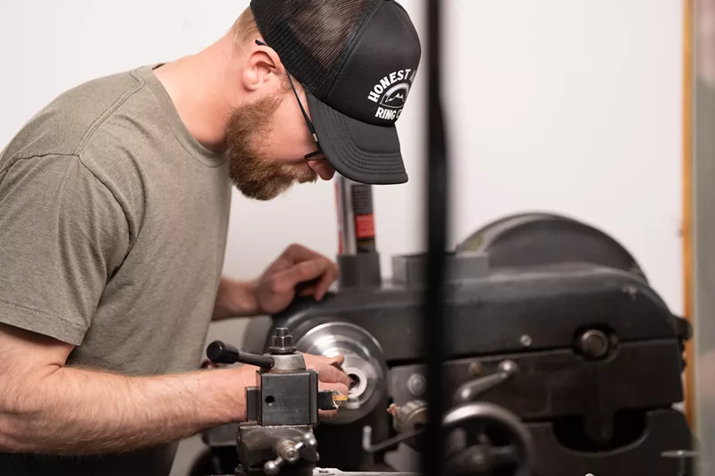 Image: Ben Bosworth working with a machine in his workshop