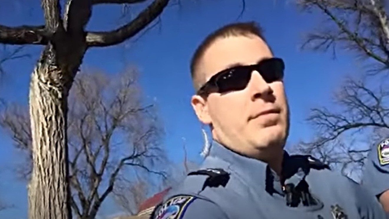 A Colorado Springs Police officer in the act of arresting Michael Sexton.