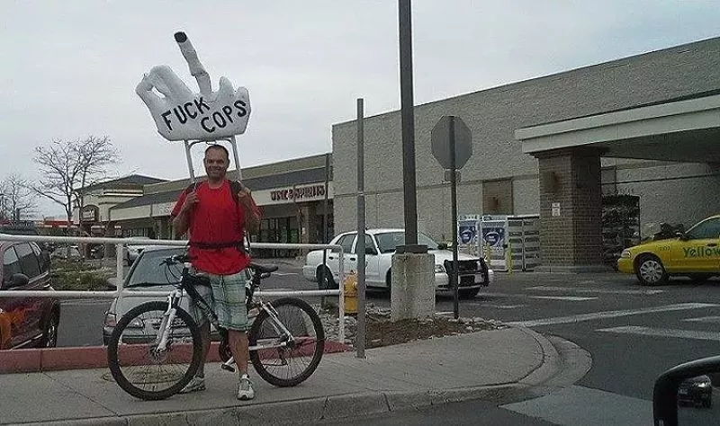 Image: Eric Brandt with one of his "Fuck Cops" displays.