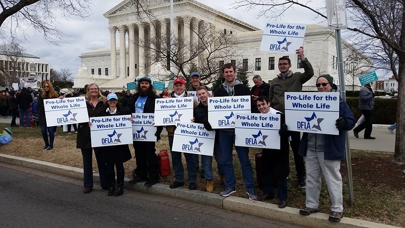 Members of Democrats for Life of America hold "Pro life for the whole life" signs at the 2017 March for Life in Washington, D.C.
