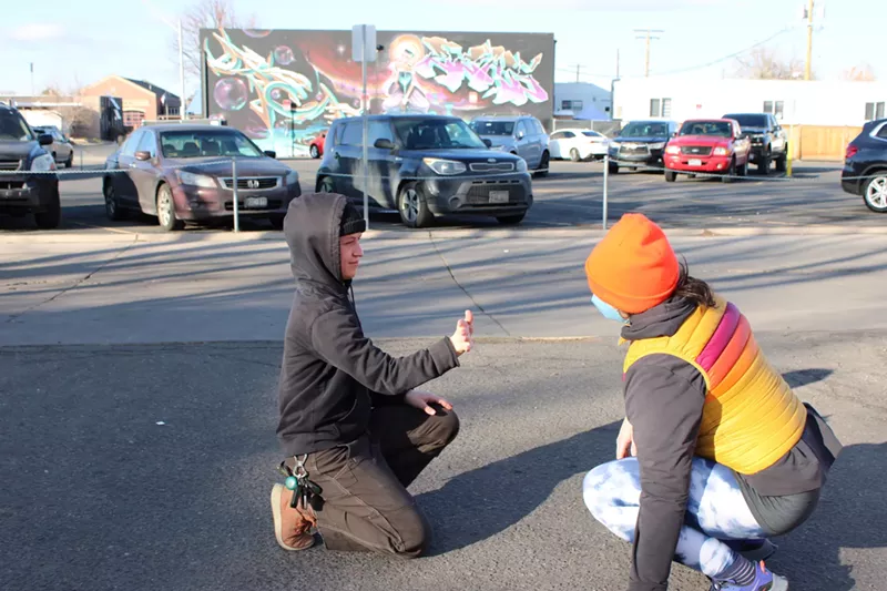 Image: A mirroring game is played by two people in a parking lot.