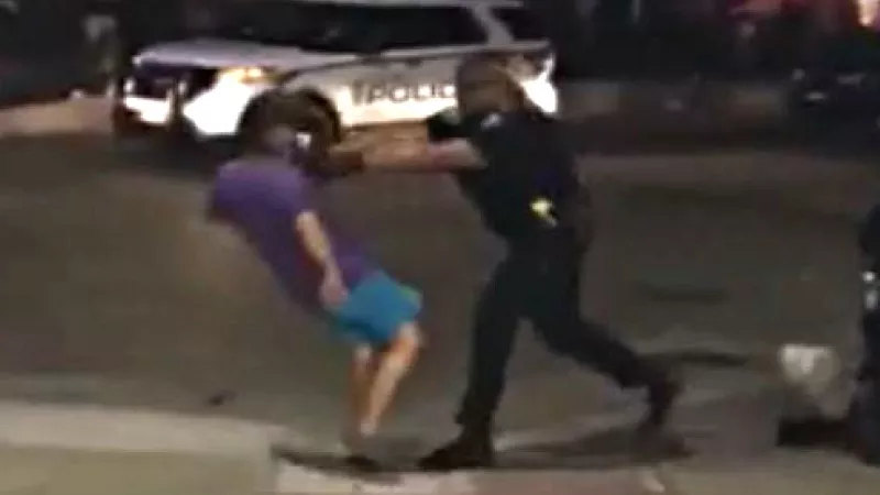 Image: A screen capture of Officer Waylon Lolotai shoving Kelly Clark. See two videos of the incident below.