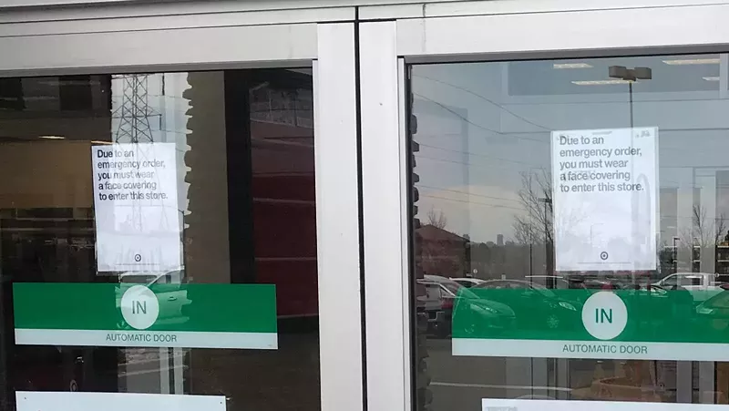 Image: Sign at the entrance to a local Target: "Due to an emergency order, you must wear a face covering to enter this store."