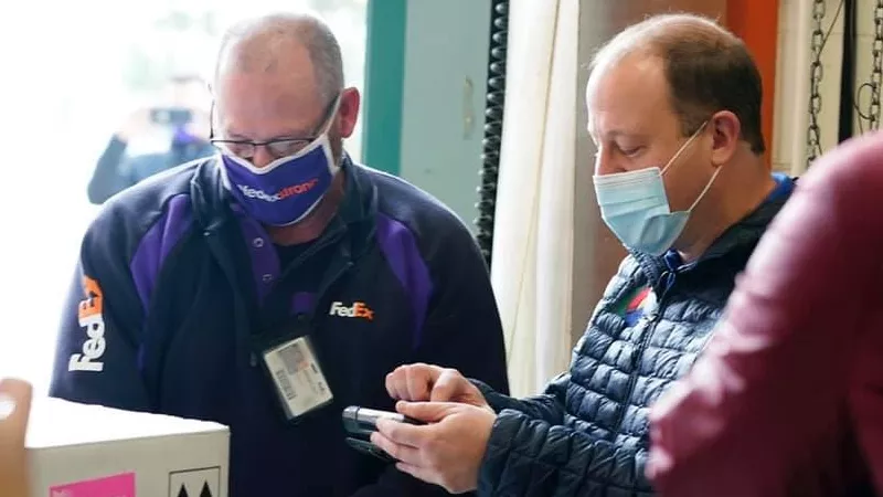Image: Governor Jared Polis signing for the first batch of vaccines to reach Colorado last month.