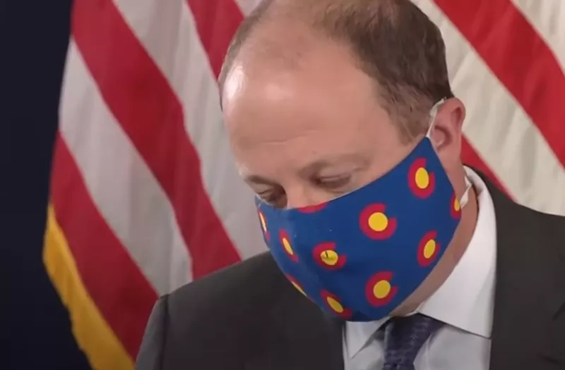 Image: A masked Governor Jared Polis.
