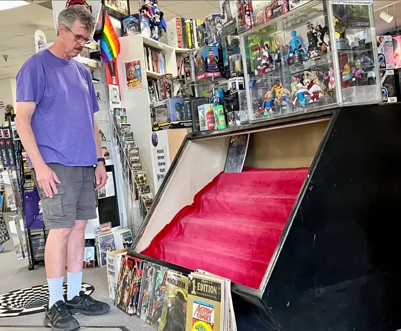 Image: Owner Wayne Winsett looks down at the case from which the expensive comic books were stolen.
