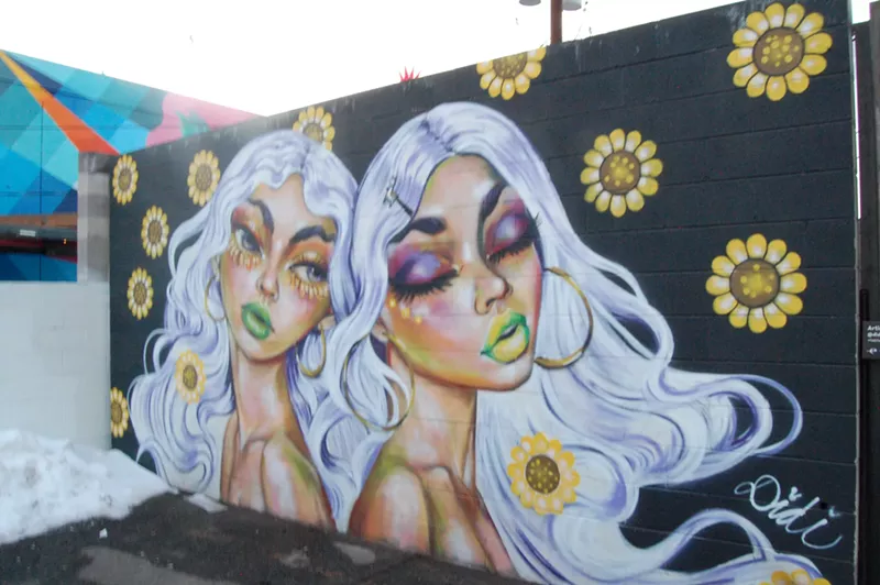Image: Diana "Didi" Perez's mural "Besties," signed with her name and accompanied by a sign that includes her Instagram handle.