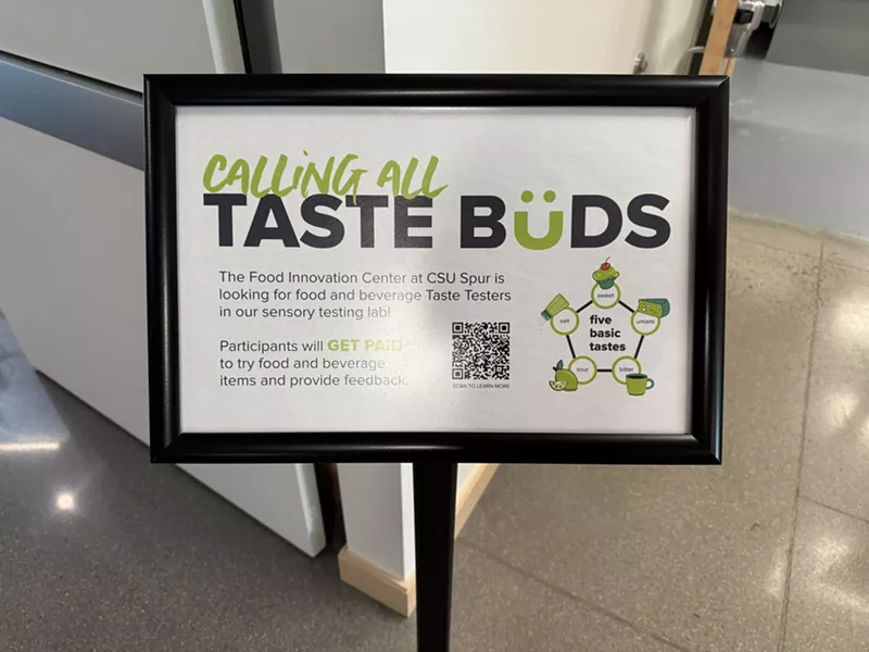 Image: a sign in a stand that says "calling all taste buds"