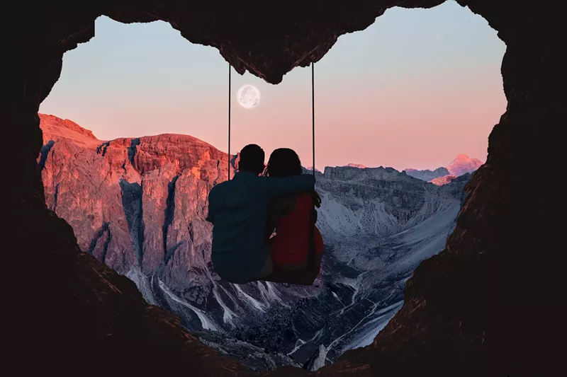 Image: romantic couple on swing looking at mountains