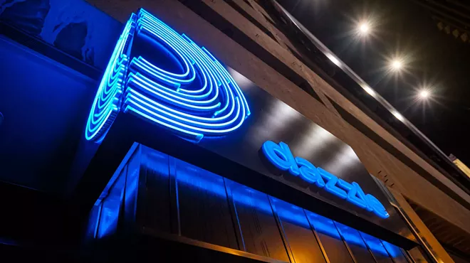 a sign that reads "Dazzle" in neon blue.