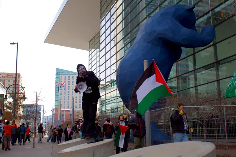Image: Pro-Palestine protestors hold signs and flags outside of the Global Conference for Israel at the Colorado Convention Center.