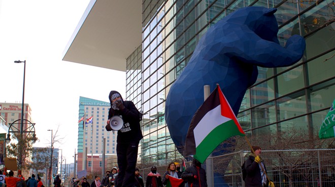 Pro-Palestine protestors hold signs and flags outside of the Global Conference for Israel at the Colorado Convention Center.