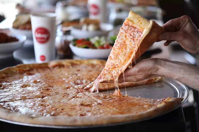 Image: slice being pulled from a cheese pizza