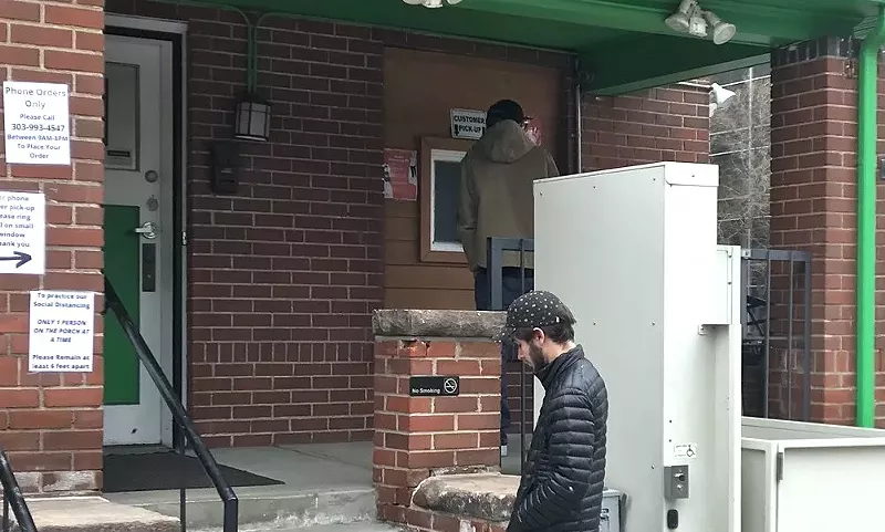 Image: Customers wait to pick up a purchase at a walk-up window at Higher Grade, a Denver dispensary.