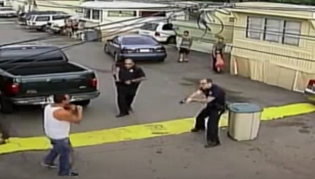 Paul Castaway with a knife to his throat as he moves toward officers, as seen in surveillance footage from the tragic scene on view below.