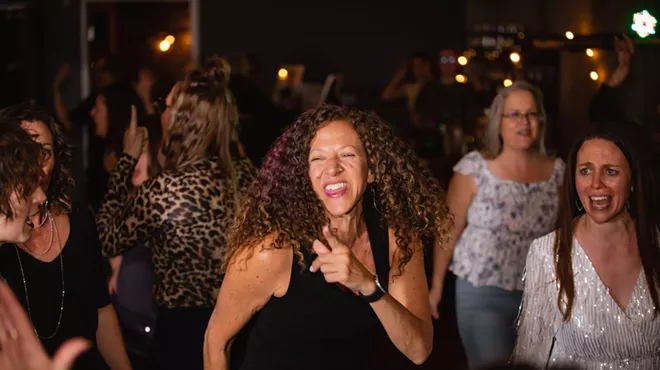 Women dance together.