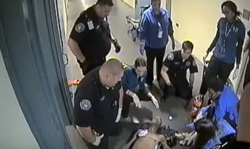 Image: Deputies and emergency personnel looking at the lifeless body of Michael Lee Marshall, as seen in surveillance video.