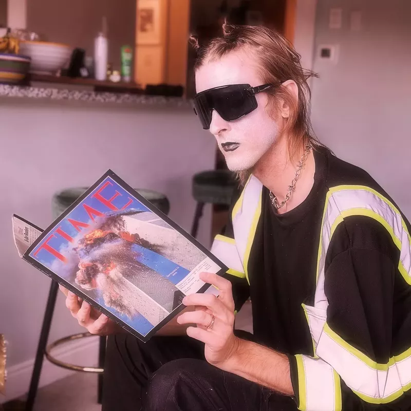 Image: goth person looking at a magazine