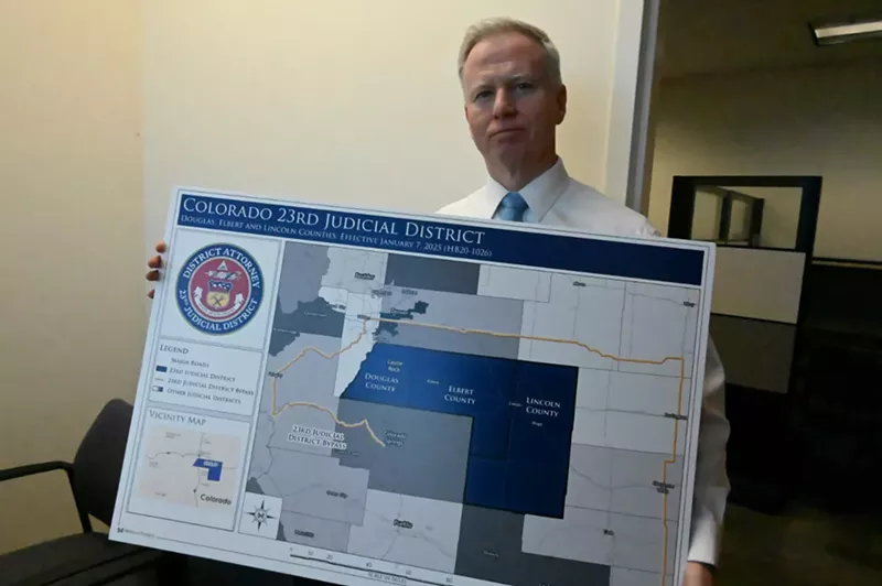 Image: George Brauchler holds up a map.