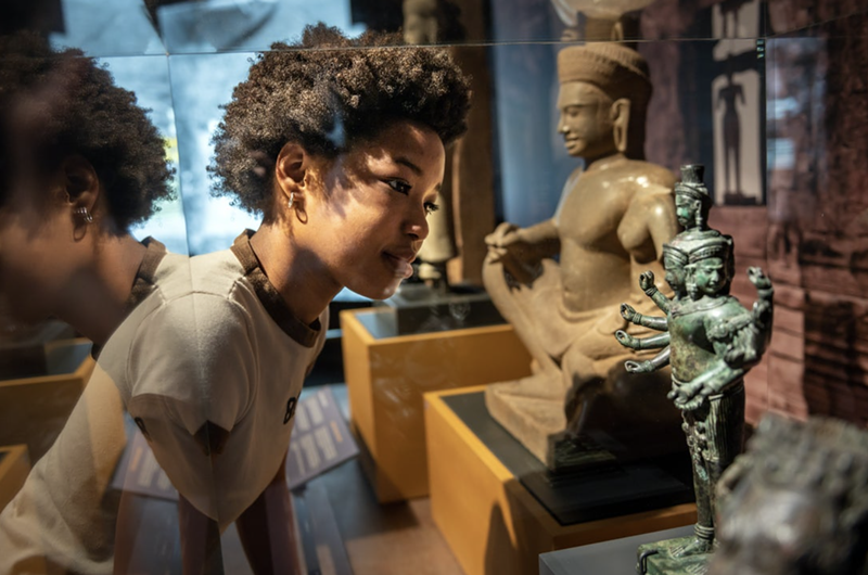 Image: A boy looks at a small statue