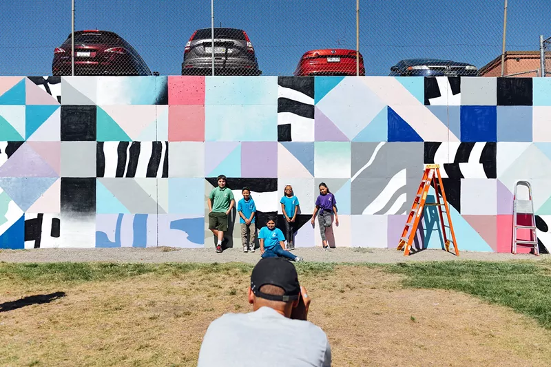 Image: International artist Saïd Kinos takes a photo of Nicholas (left), Nico, Nivia, Timberly and Christine in front of a mural he painted with their help on Friday, September 15, at Cowell Elementary School.