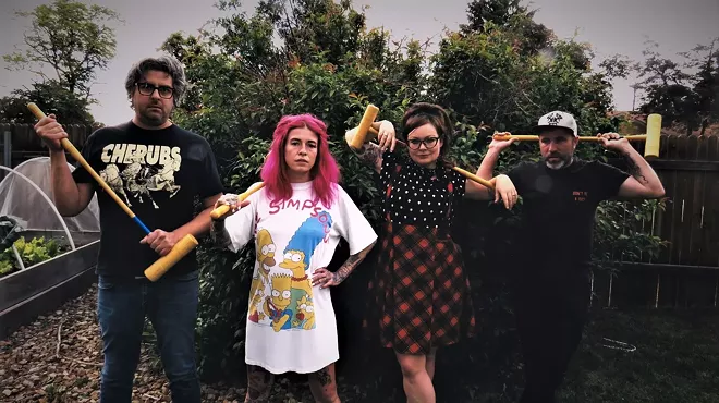 two men and two women standing in a yard