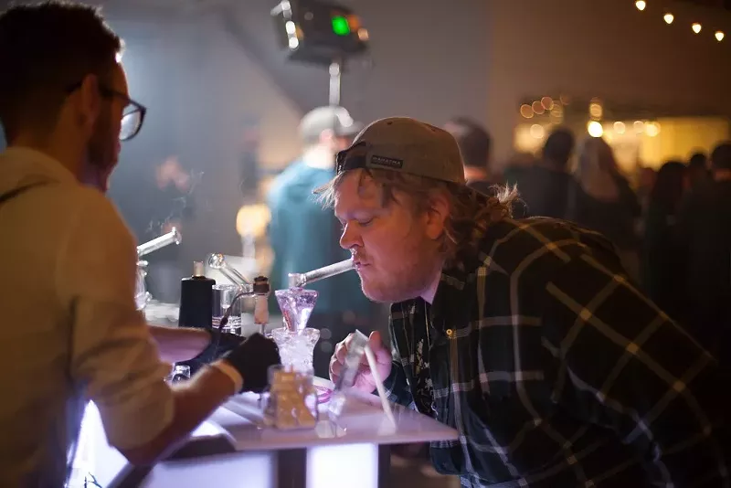 Image: A man takes a dab inside a private party held by the Grow Off.