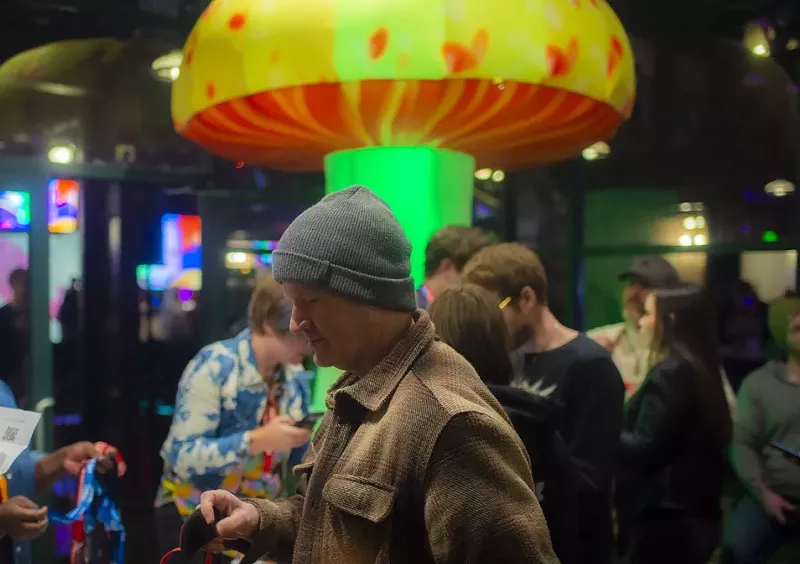 Image: Man in a beanie stands in front of inflatable giant mushroom