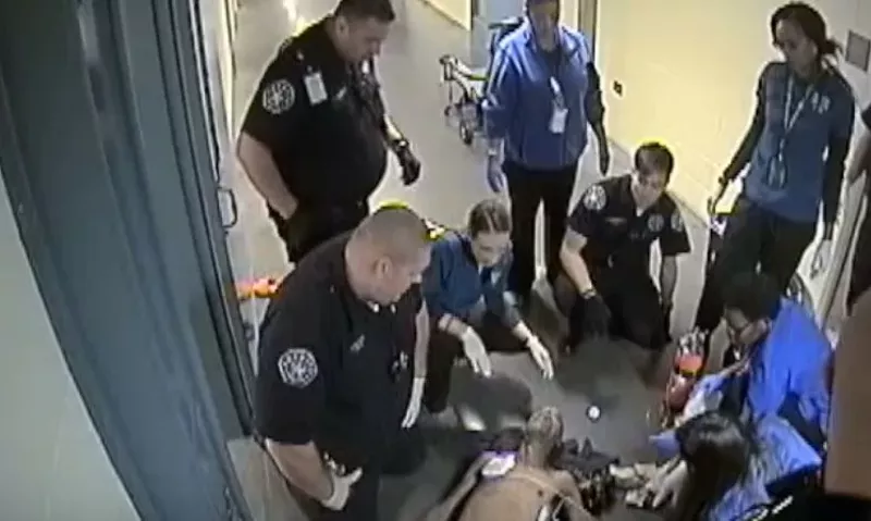 Image: Deputies and emergency personnel looking at the lifeless body of Michael Lee Marshall, as seen in surveillance video.