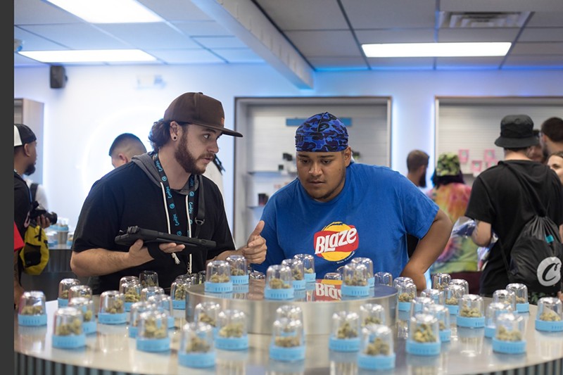 A dispensary shopper in Commerce City views his options with an employee.