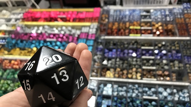 person holding a 20-sided dice