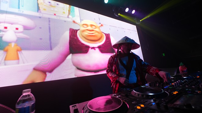 man deejaying with image of shrek in the background
