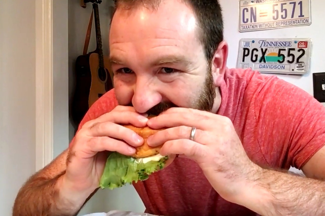 Nick Evans takes a big bite out of a Smashburger burger — strictly for research purposes, of course.