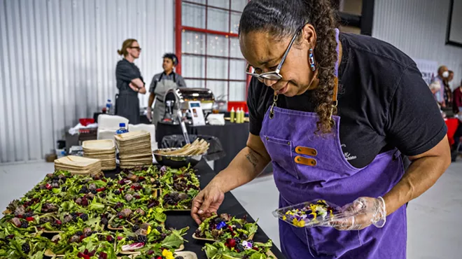 A chef plating multiple salad dishes at Denver EATSS