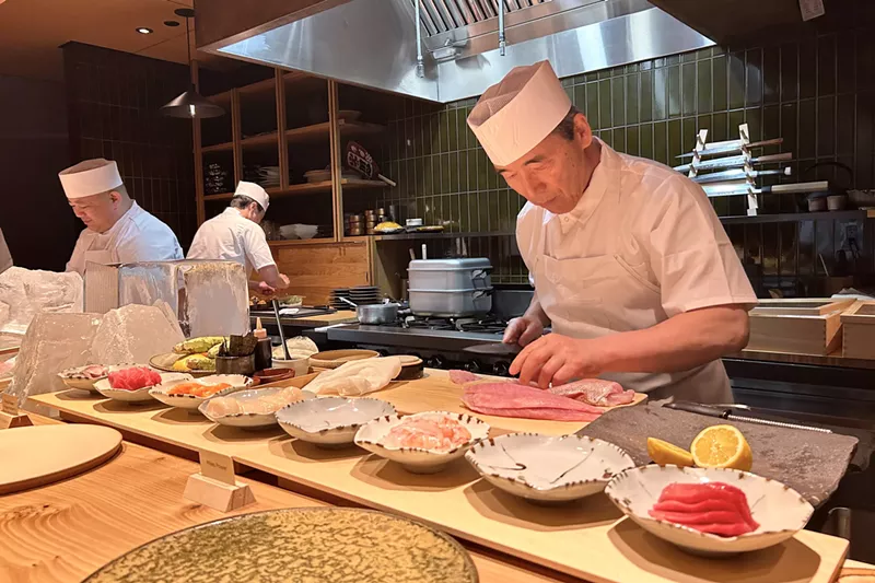 Image: Toshi Kizaki preparing raw fish at the omakase counter