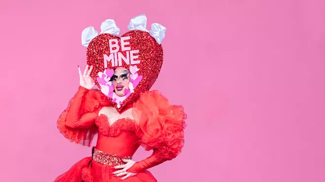 A drag performer strikes a pose in red.