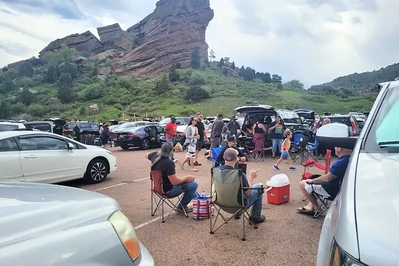 Image: A group tailgating in the Red Rocks parking lot, backdropped by a large rock formation