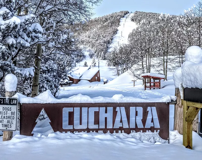Image: A large Cuchara Mountain Park sign backdropped by Baker Mountain ski slopes