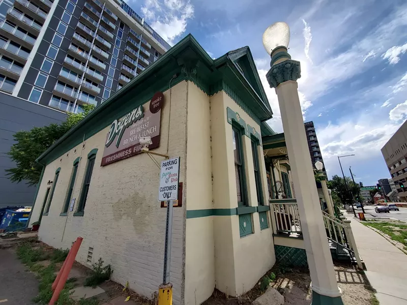Image: the corner view of a white building with green trim