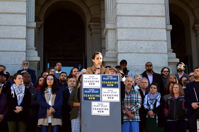 Image: woman at podium at Colorado Capitol while people listen.
